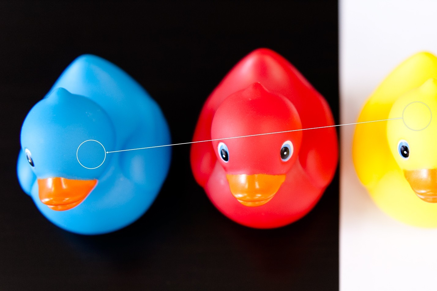 Een stukje van het hoofd van het gele badeendje wordt over het oog van het blauwe badeendje geplakt