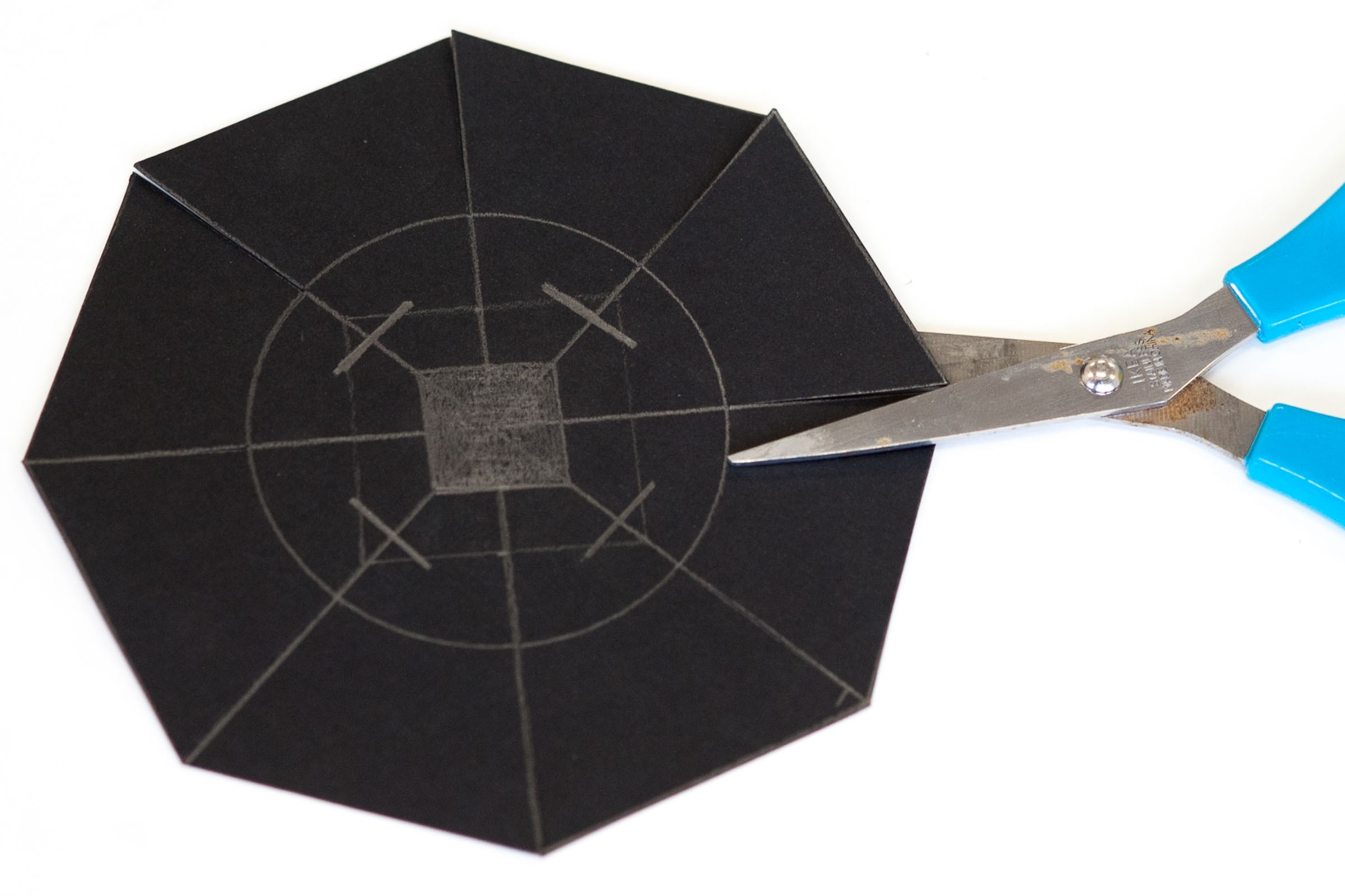 Maak nu een achthoek van het vierkant. De middelste lijn knip je in tot de cirkel.