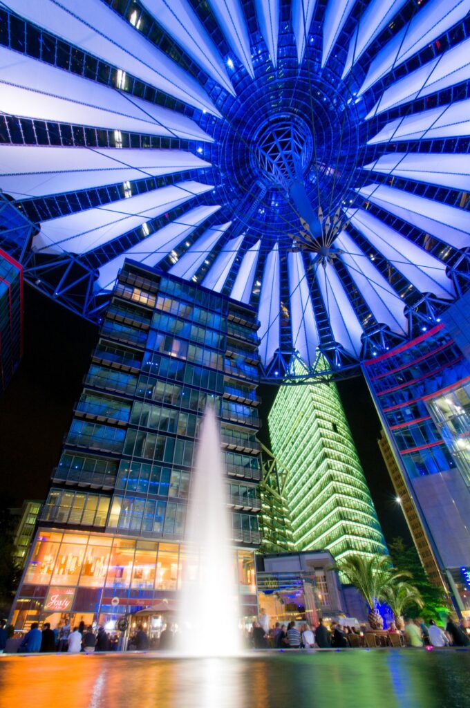 Het lage standpunt (kikkerperspectief) en het groothoekobjectief maakten de koepel van het Sony Center in Berlijn een belangrijk deel van de compositie. Door de sluitertijd van 6 seconden werd het water van de fontein wazig.