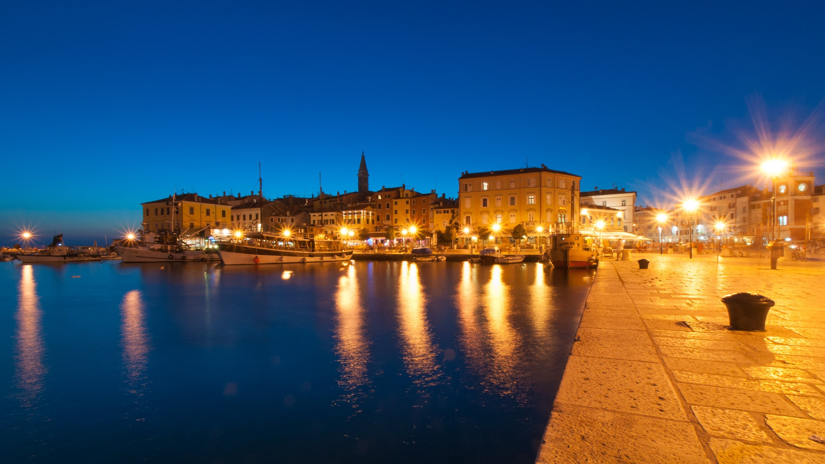 Lichtbronnen zoals lantaarnpalen geven mooie, lange reflecties in het water.
