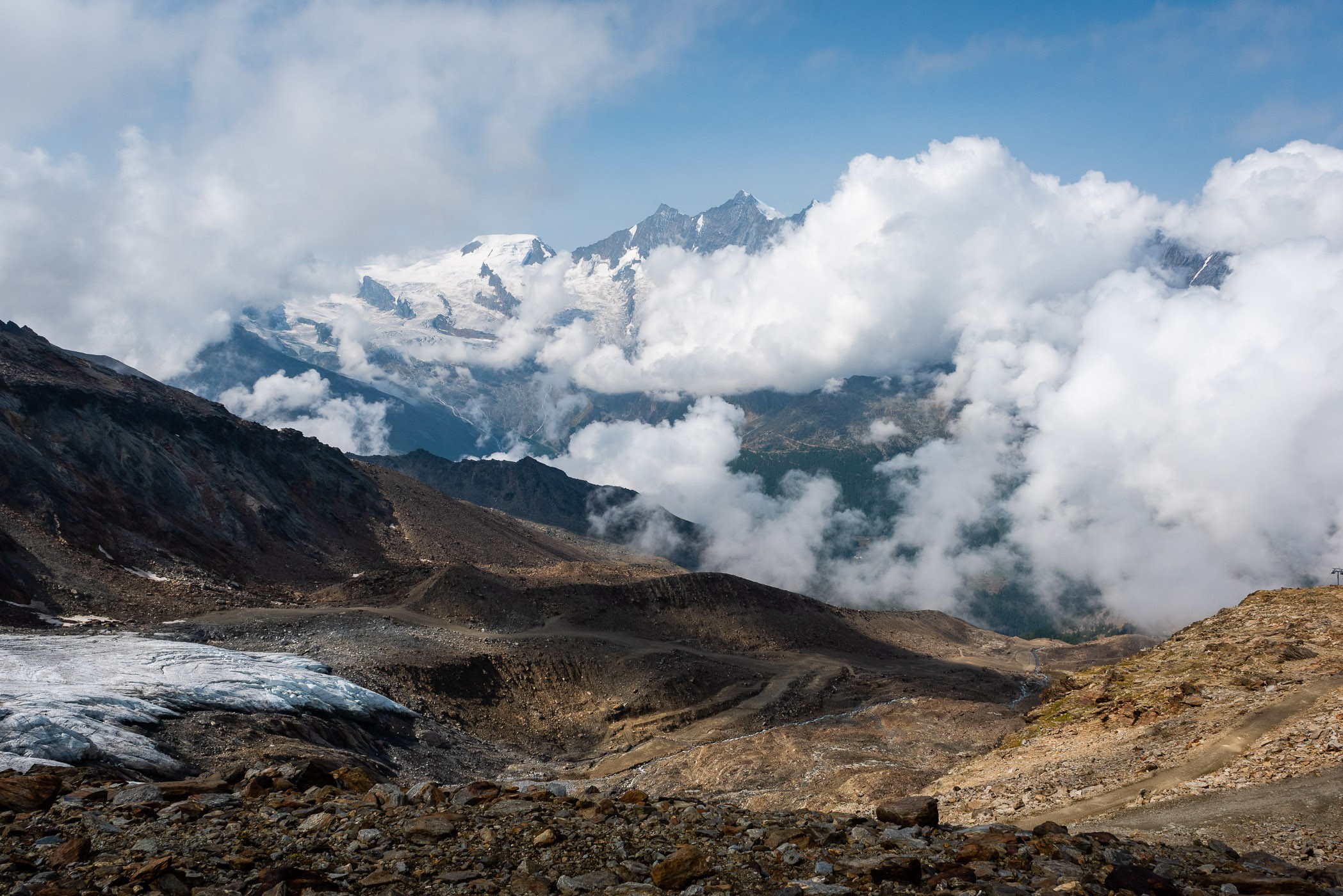 In het dal regende het lichtjes. Met kabelbaantje gingen we omhoog. En bovenaan hadden we een mooi uitzicht op de wolken die om de toppen zweven.