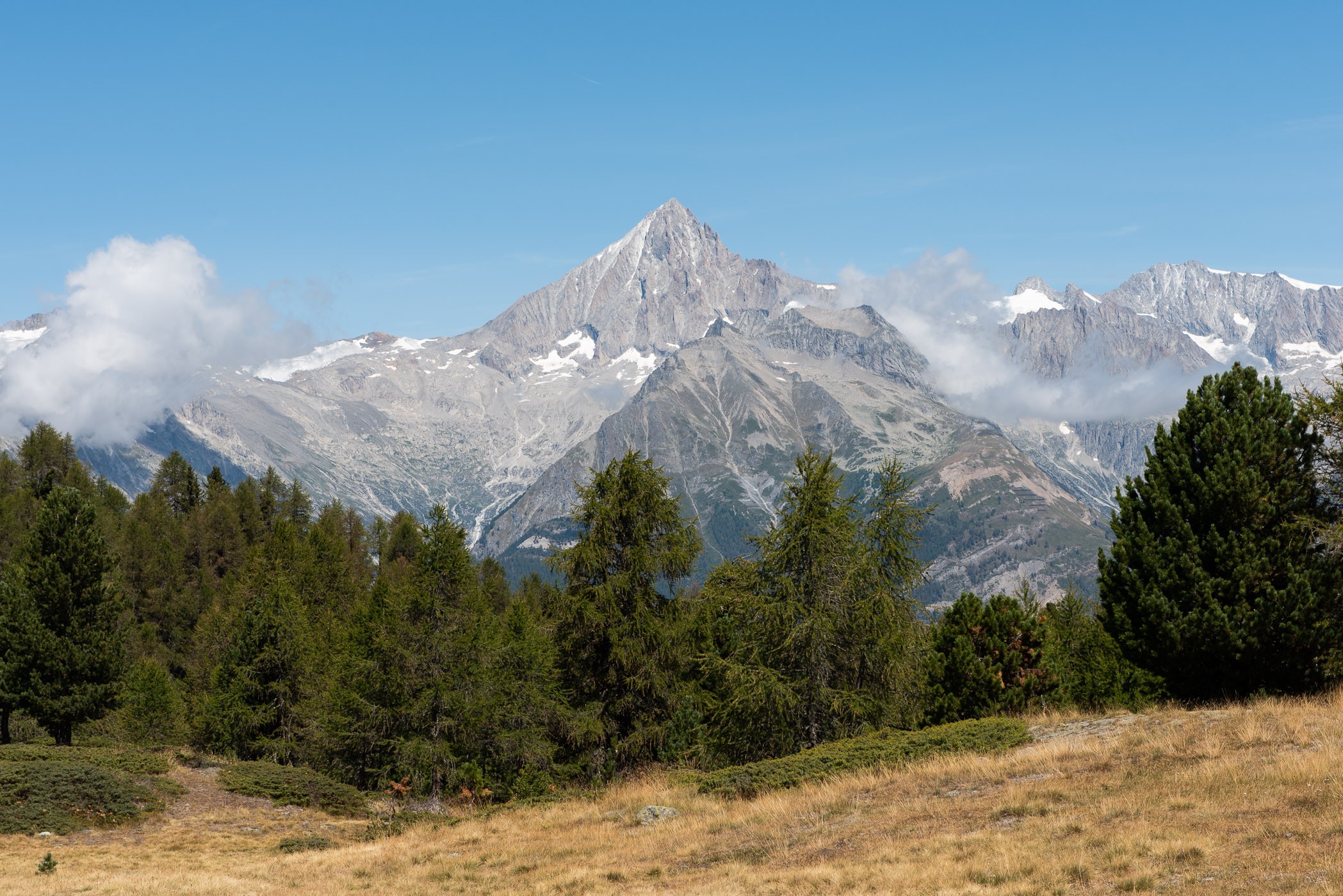 De zon staat hoog aan de hemel, geen schaduwen meer bij het berglandschap