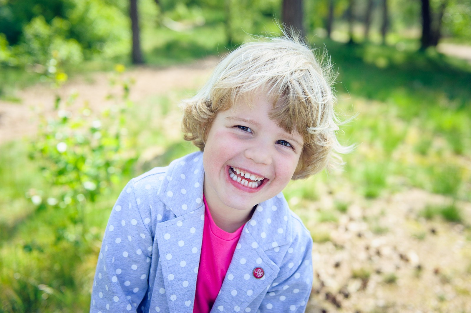 Het meisje op deze foto heeft een spontane glimlach, ze kijkt net niet naar de camera