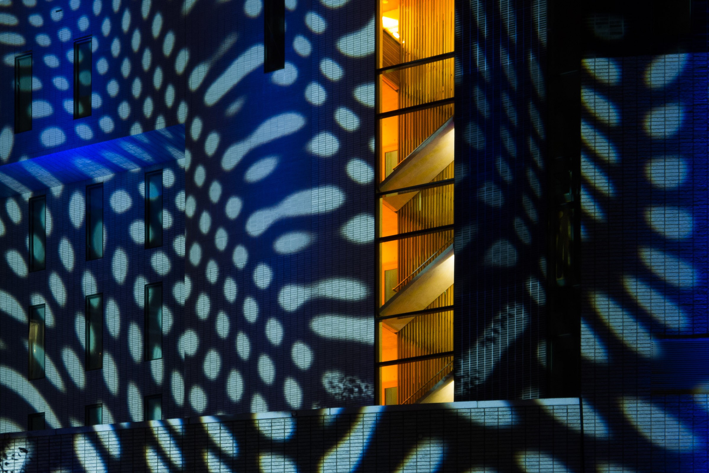 Het gele licht van binnen geeft een mooi contrast met de licht blauwe projectie. Het beeld werd door het inzoomen abstracter.