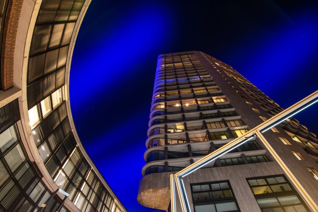 In deze foto draait het meer om het gebouw dan om het lichtkunstwerk. Op de voorgrond zie je nog een deel van één lichtkunstwerk, het blauwe licht in de lucht komt van het kunstwerk 'Something Blue' van Kari Kola