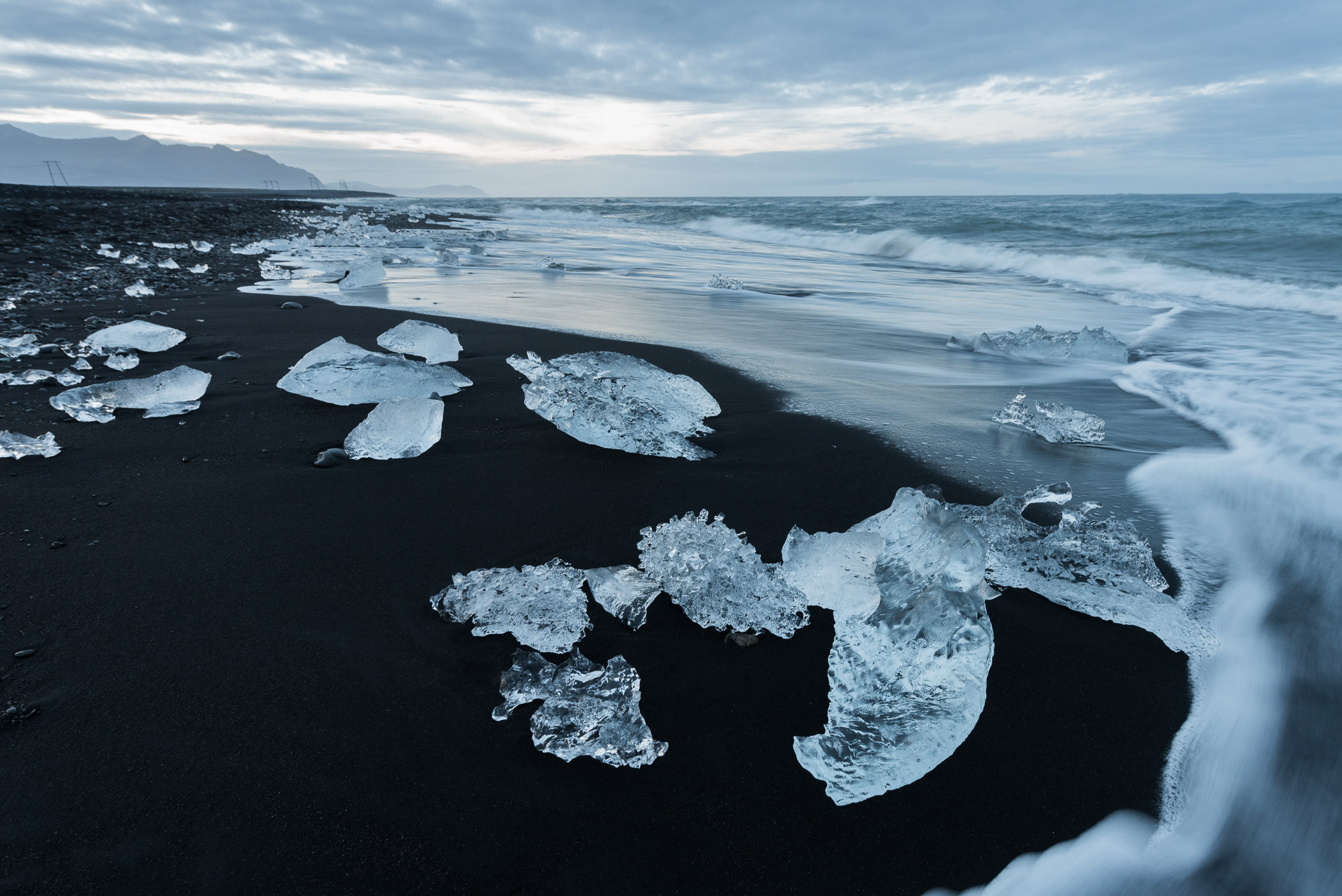 Zwart strand met ijsblokken