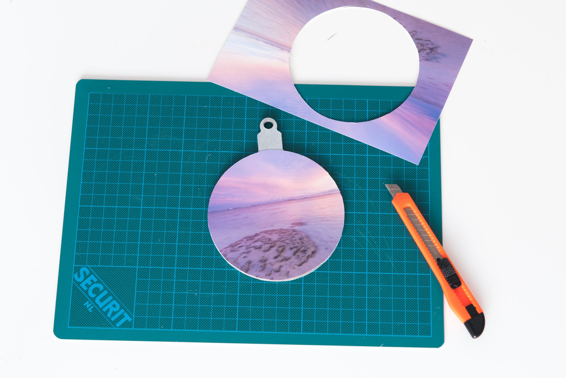 Houd het mesje niet te schuin langs het randje, anders snijdt je in de kerstbal zelf. Als je netjes werkt, kun je zo de ronde kerstbal eruit halen.