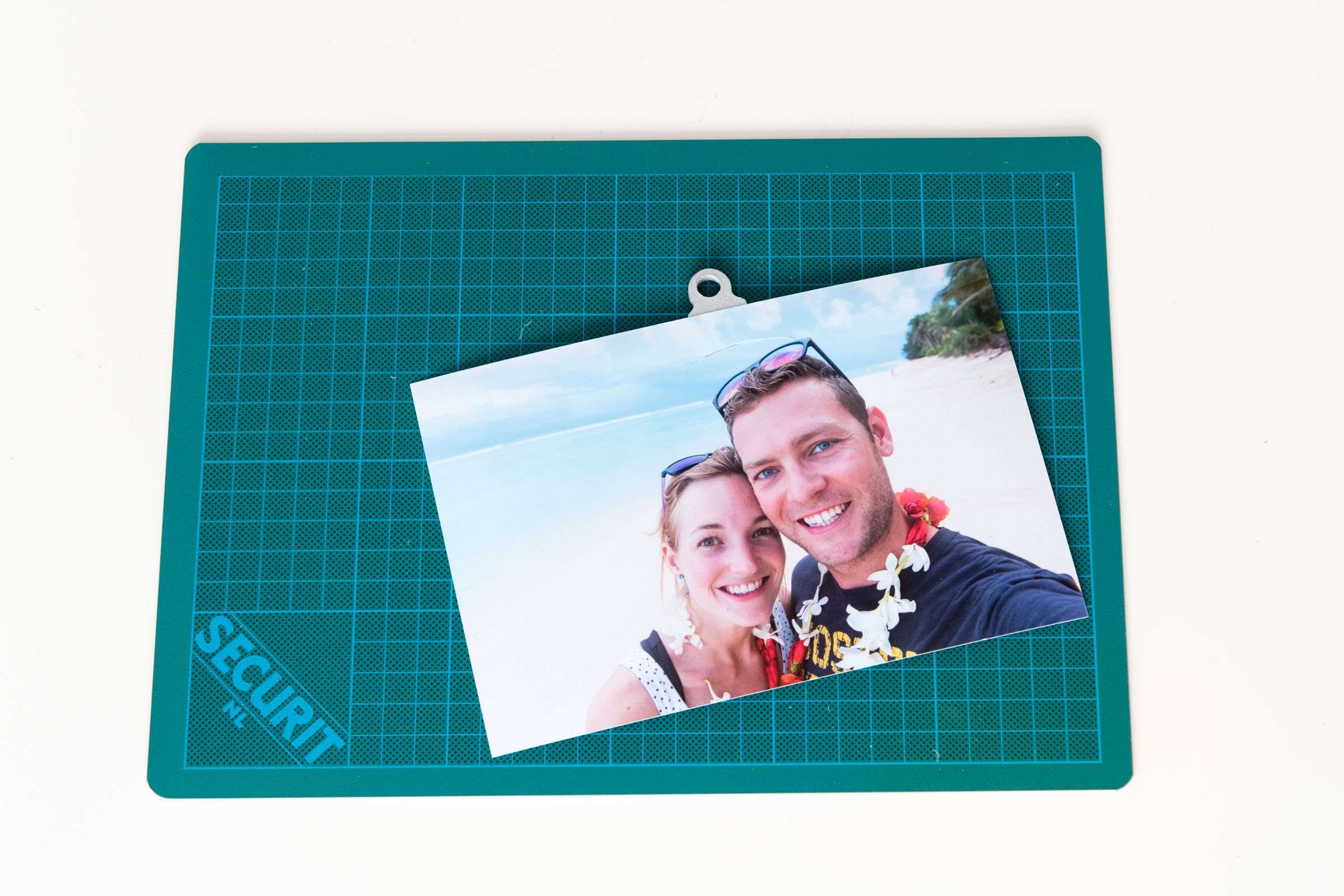 Ik plak de foto op de kerstbal. De lijm is eerst nog droog, dus je kunt deze goed op z'n plek schuiven. Het helpt om de foto en de kerstbal even tegen het licht aan te houden en te controleren of deze precies goed zit.