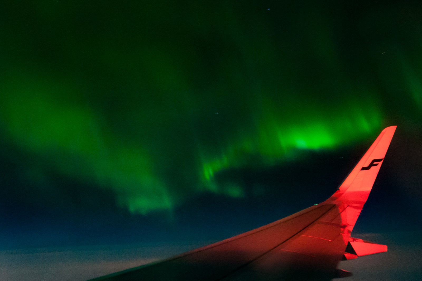 Het noorderlicht vanuit het vliegtuig.
