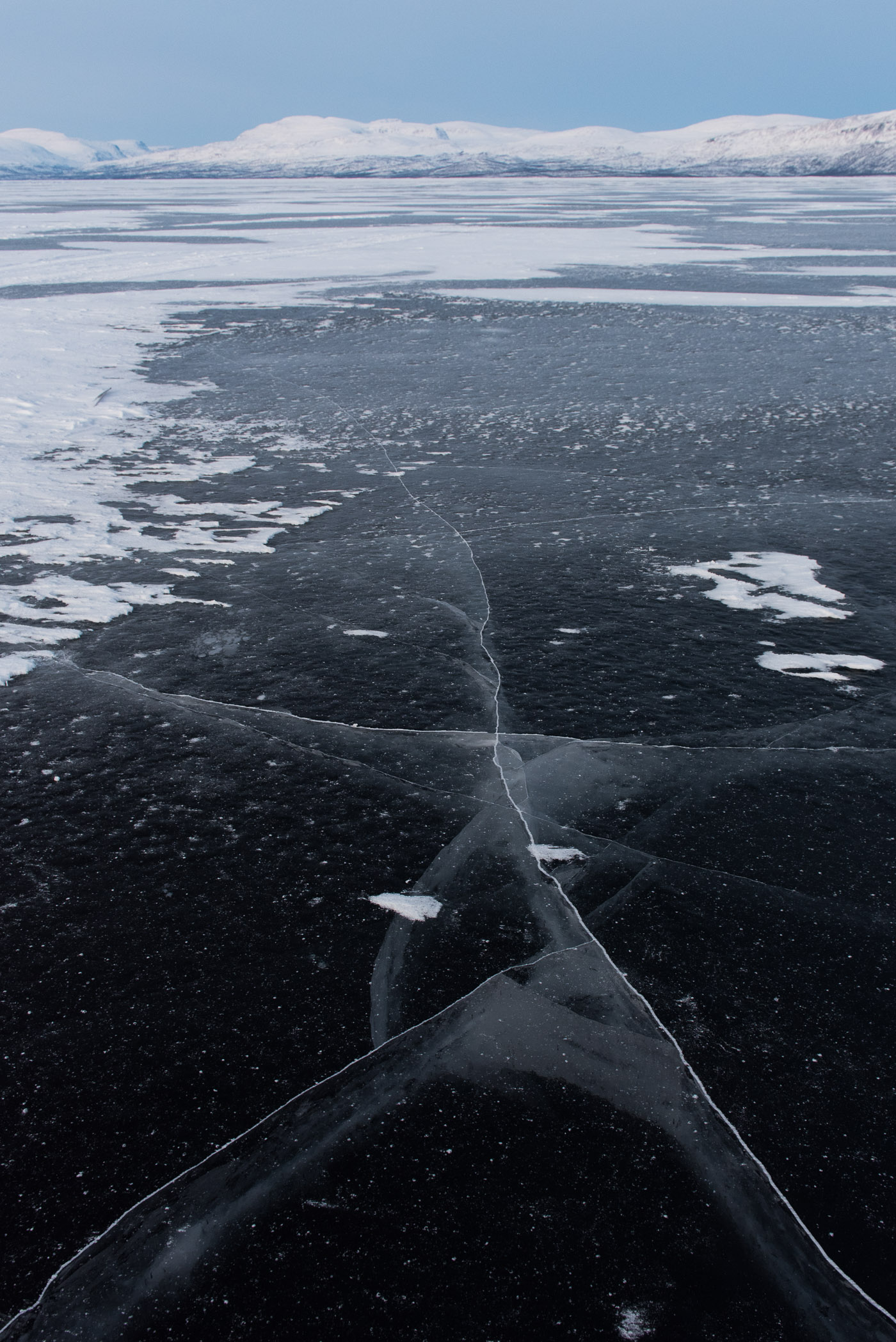 Bevroren meer met scheur die in de verte wegloopt