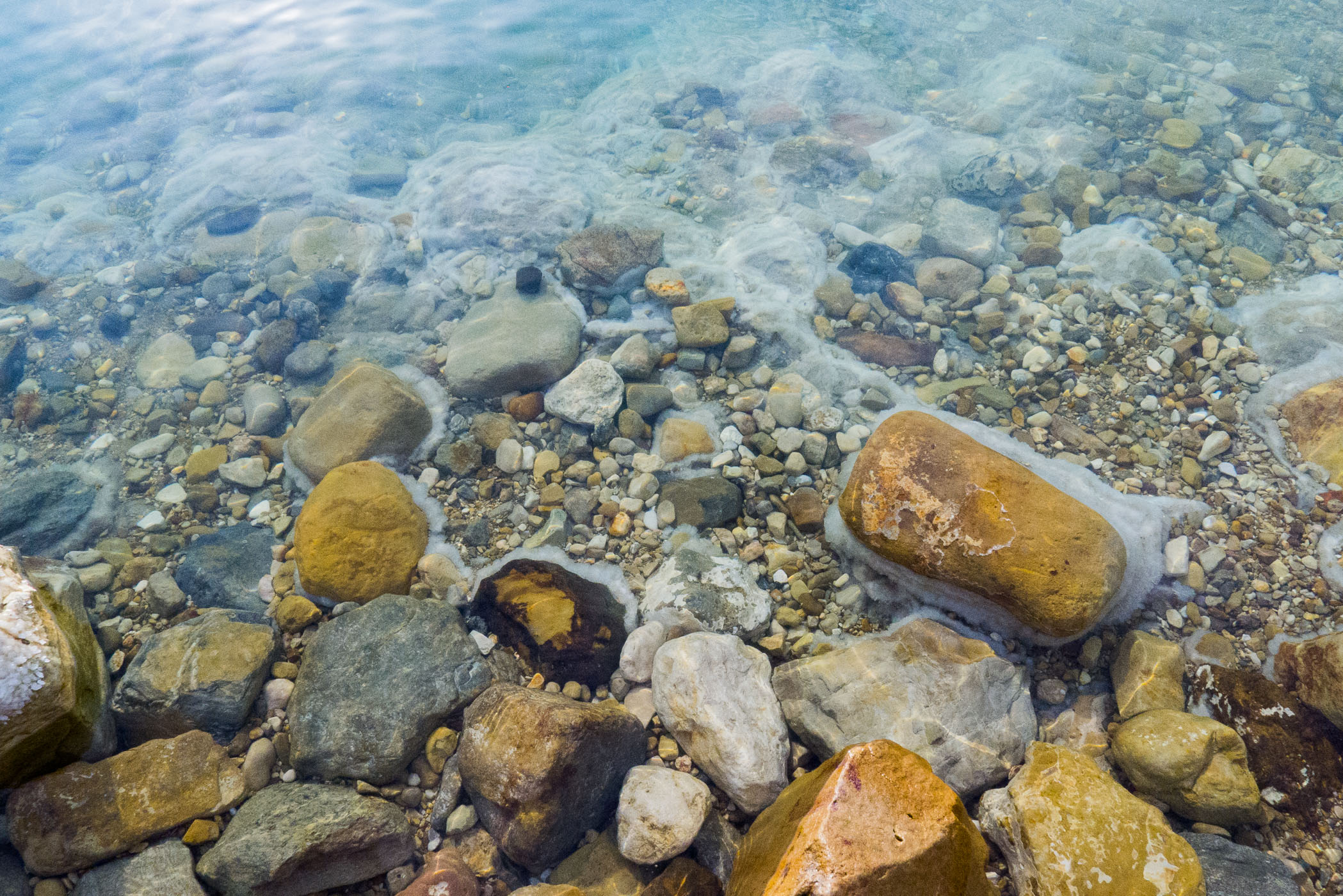 Je ziet de zoutlaag om de rotsen