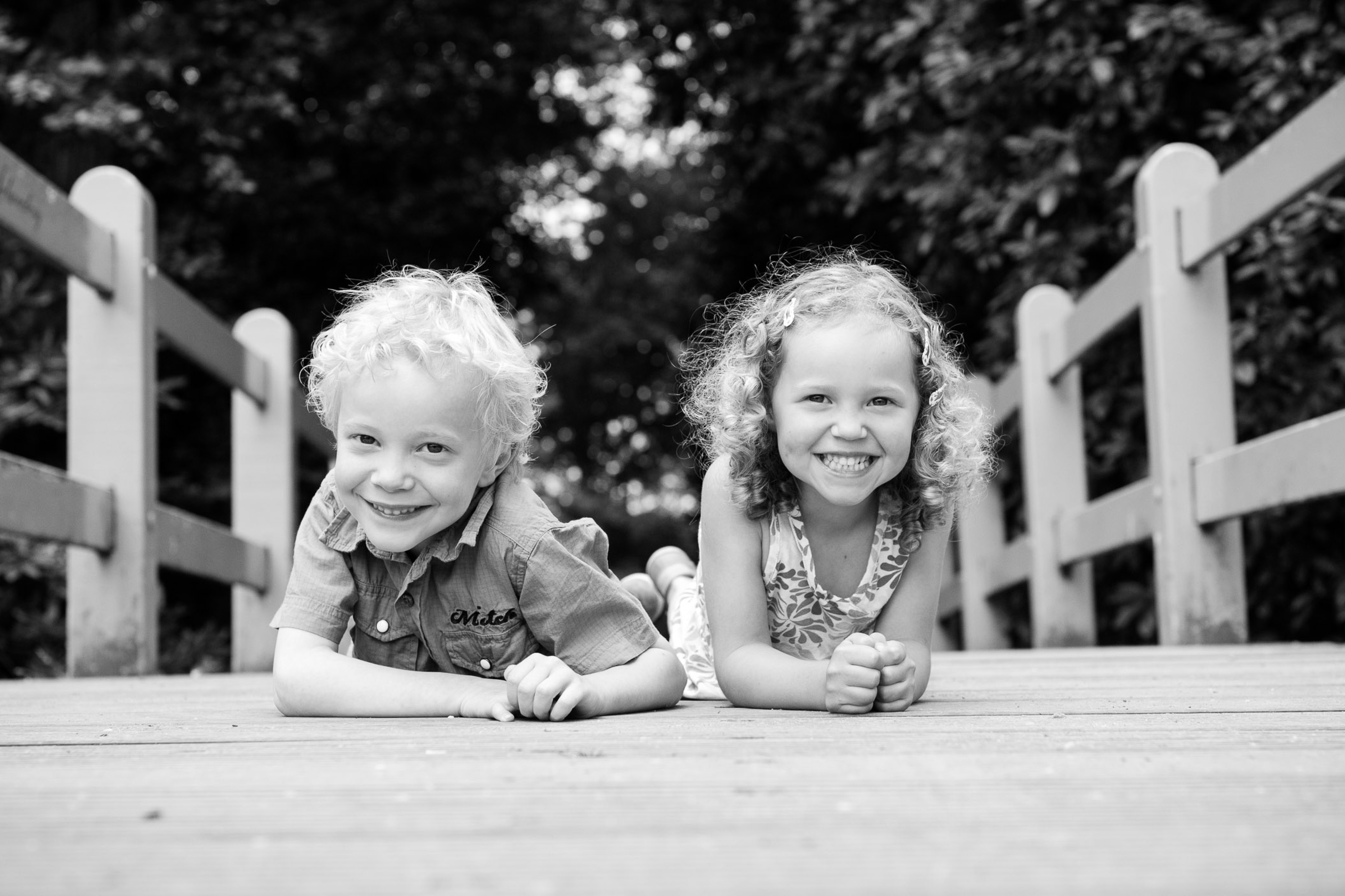 Twee kinderen poseren op een brug voor de foto