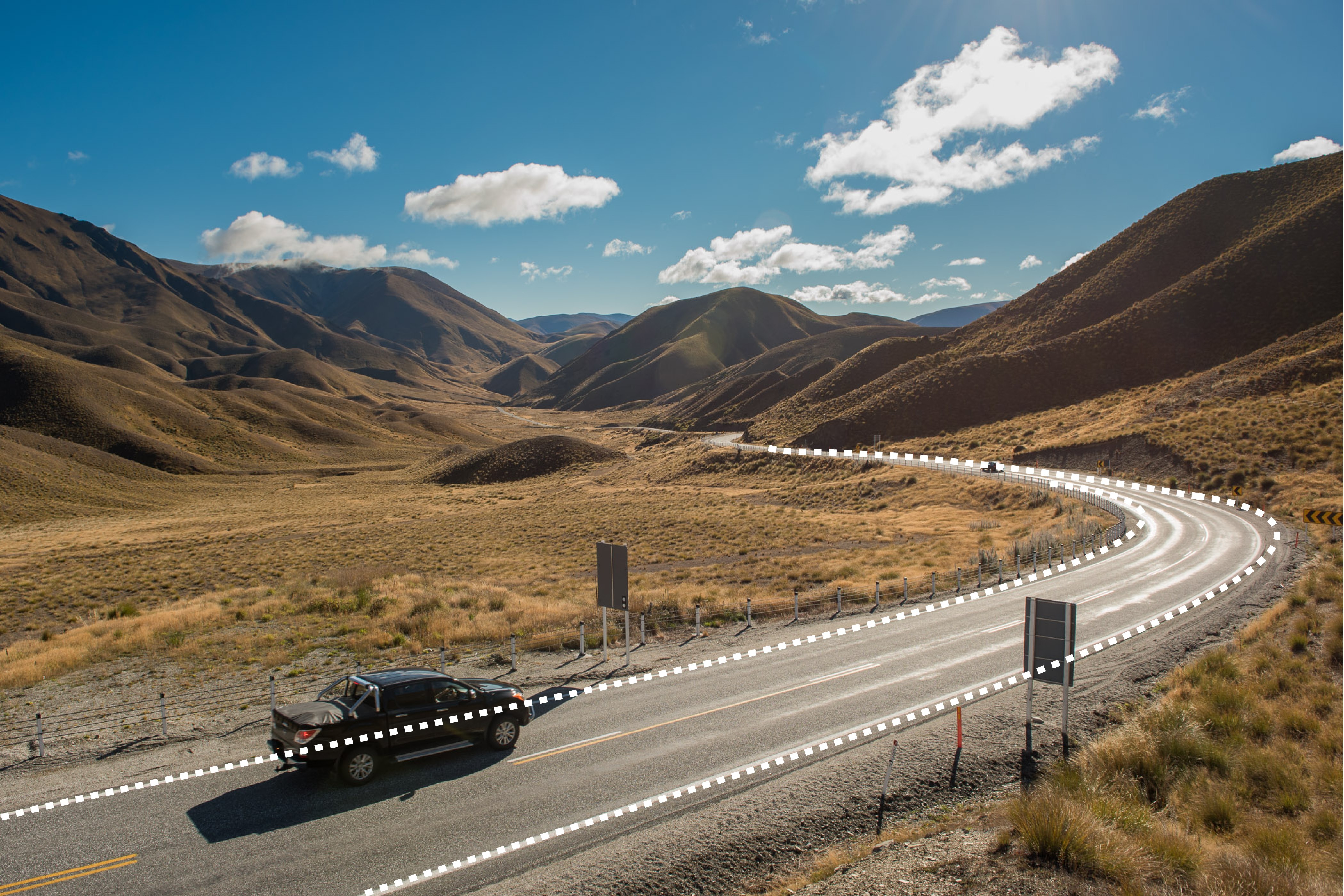 De weg vormt een leidende lijnen door de foto, de auto neemt je ook als het ware mee