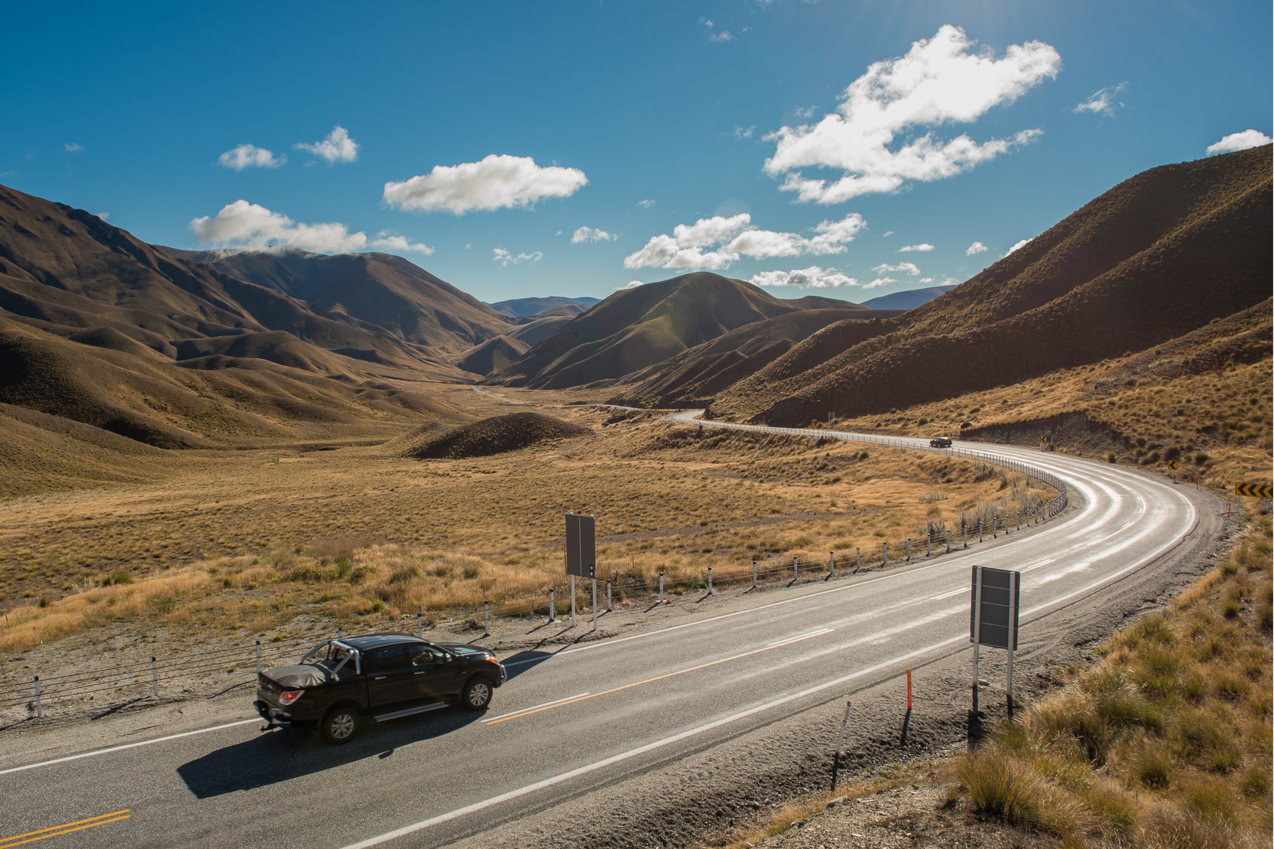 Auto rijdt over de Lindis Pass in Nieuw Zeeland
