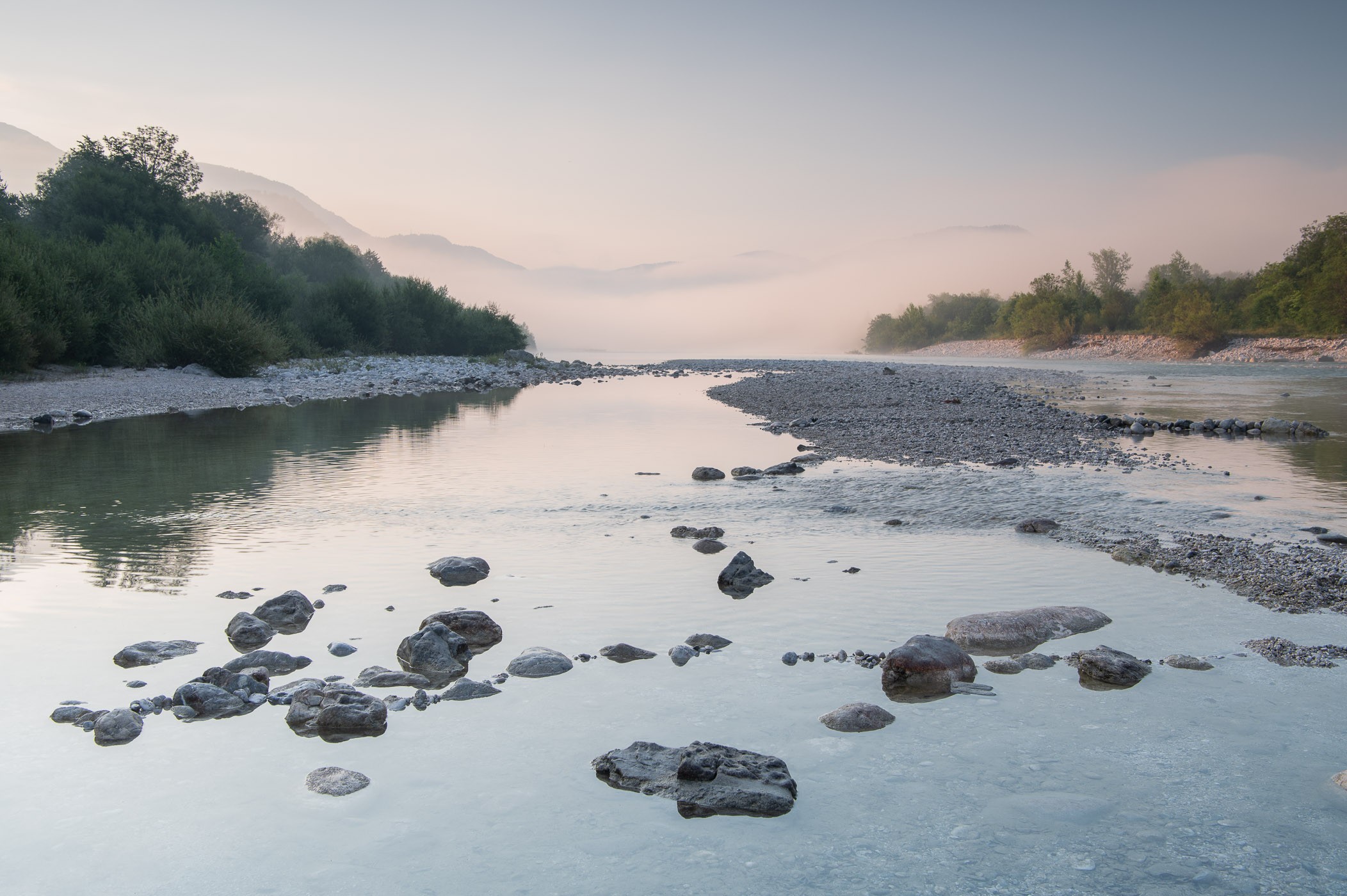 Rivier met mist tussen de heuvels in de verte