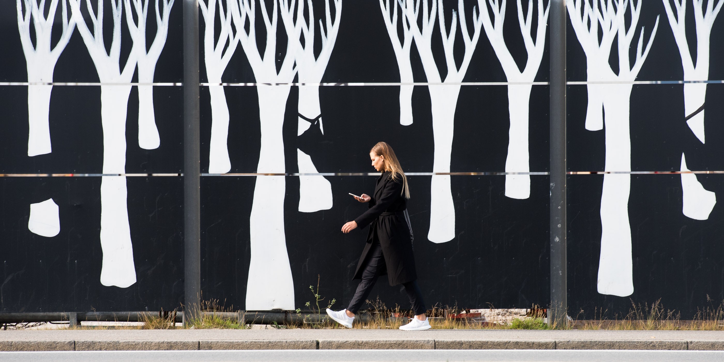 Dezelfde muur als de foto's hierboven, maar dan een eind verder op. Ik wist dat ik de dame precies in het midden van het beeld wilde plaatsen, zodat ze met haar zwarte jas en broek zou 'wegvalen' in het zwart van de achtergrond. Haar hoofd, handen en schoenen krijgen hierdoor extra aandacht.