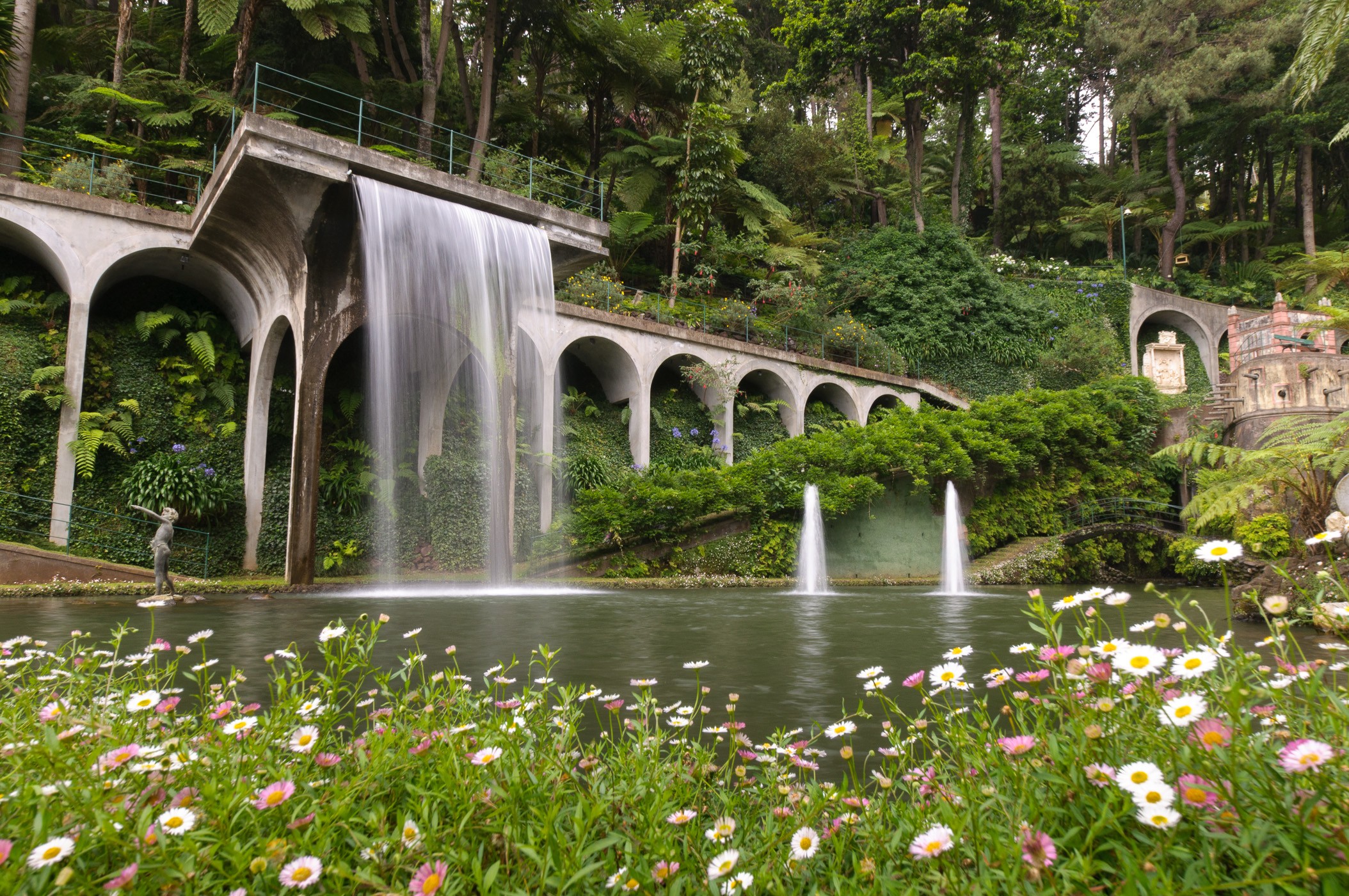 Een kunstmatige waterval bij de botanische tuinen in Funchal, Madeira. De bloemen op de voorgrond geven de foto diepte.