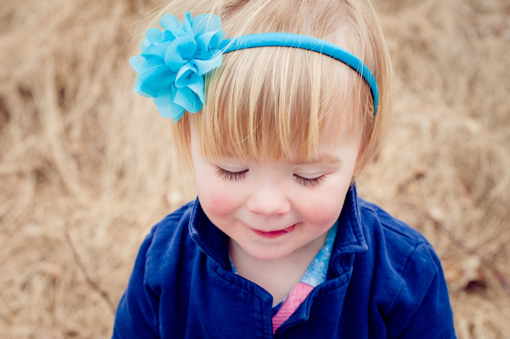 Meisje dat omlaag kijkt en een klein stukje tong uitsteekt